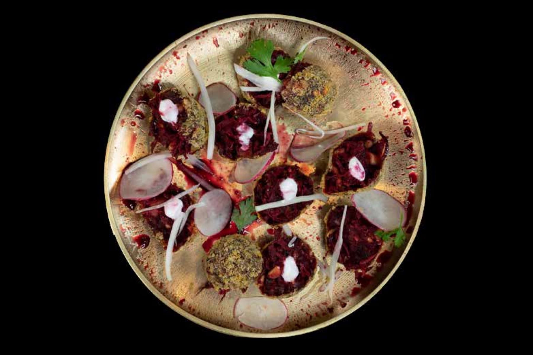 Beetroot galouti canapés on a brass thali, plated by Cater Inc
