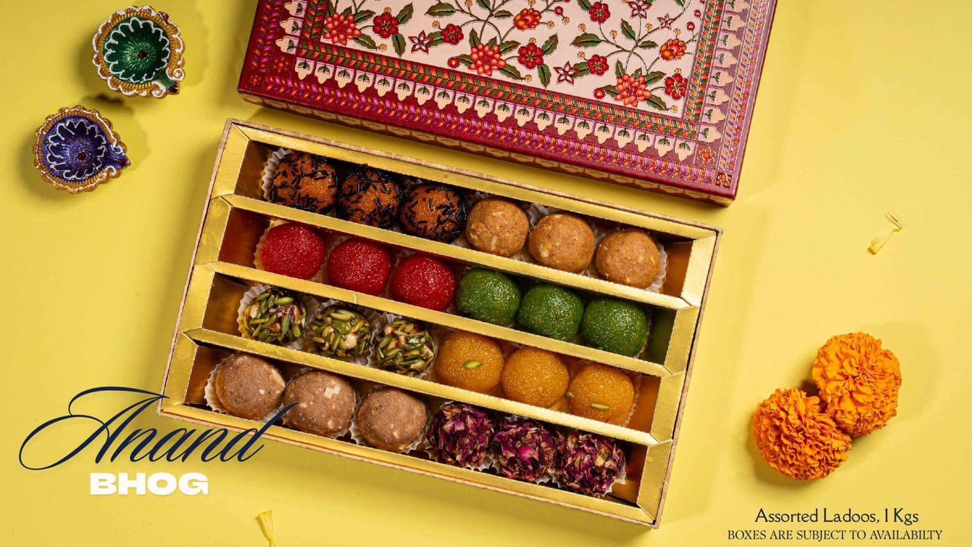 The Anand Bhog box from Chhappan Bhog, rows of assorted ladoos under a floral lid