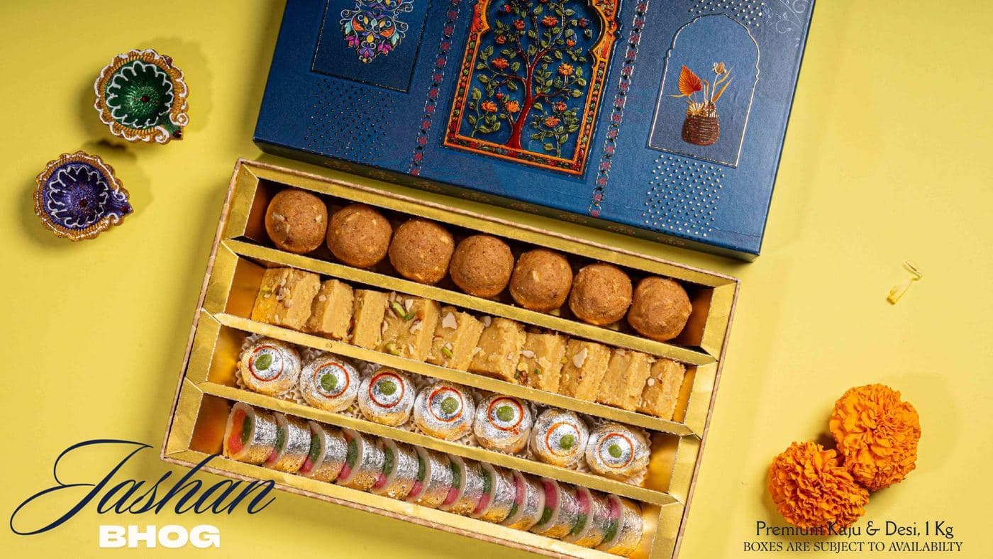 The Jashan Bhog box from Chhappan Bhog, with ladoos, barfi and kaju rolls under a blue Mughal-print lid