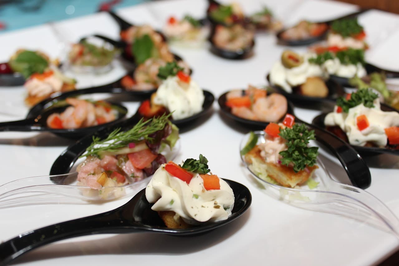 Canapés served on spoons: prawns, tartare and piped cream cheese