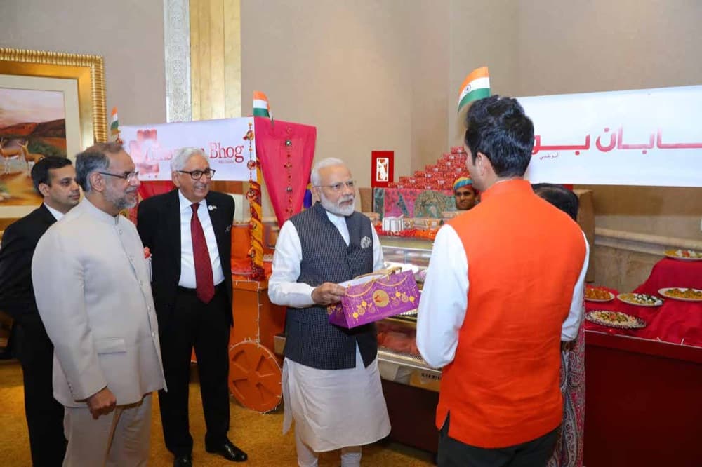 Prime Minister Narendra Modi receiving a box of handcrafted Chhappan Bhog sweets at Emirates Palace